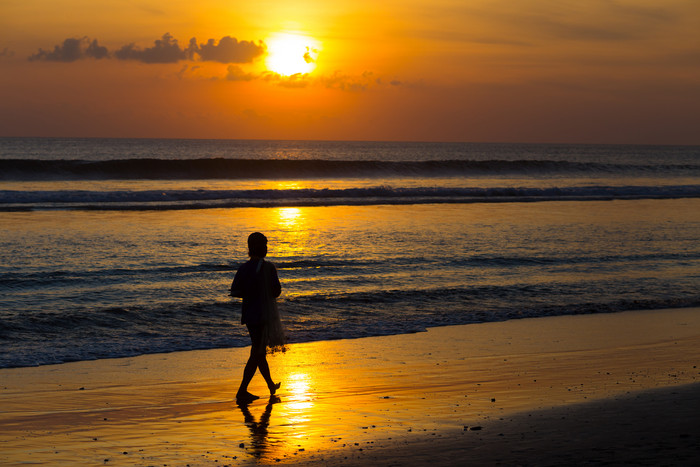 深色黄昏海边散步的人摄影图