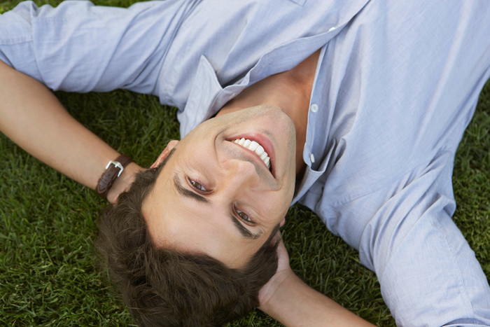 微笑躺在草地上的男子