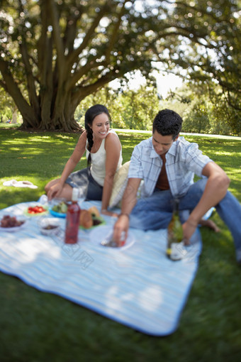 草坪野餐的情侣摄影图