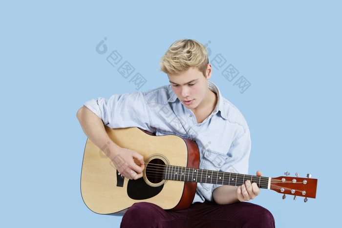 蓝色调弹吉他的男孩摄影图