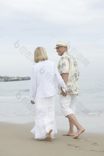 沙滩牵手散步的夫妻