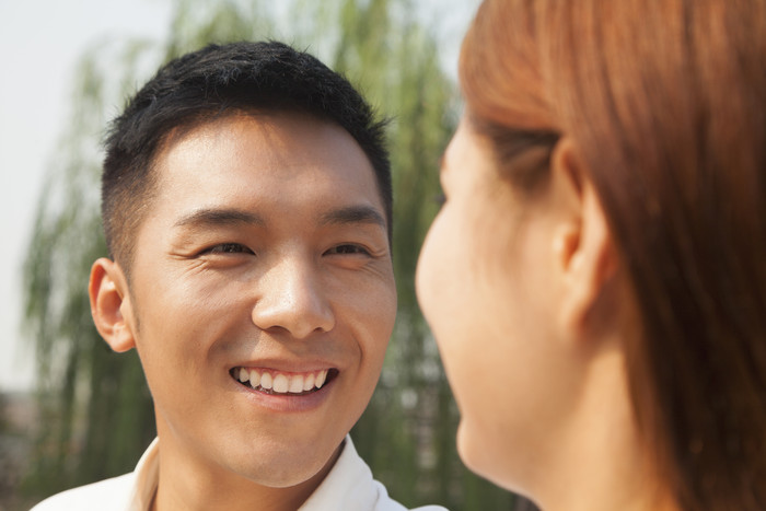 年轻的男人女人夫妻情侣河边约会面对面微笑