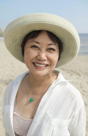 沙滩上戴着遮阳帽的中年女人