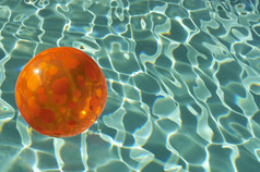 深色调泳池中的球摄影图