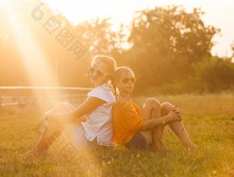 暖色调草地上的姐妹摄影图