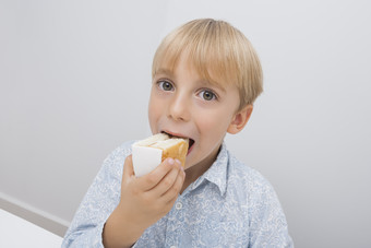 简约吃面包的孩子摄影图
