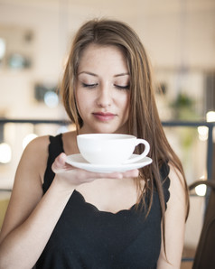 深色调喝咖啡的一个女人摄影图