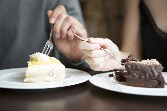 深色调吃蛋糕的情侣摄影图