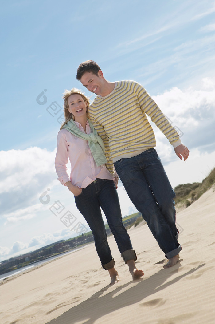 沙滩牵手散步的夫妻笑脸