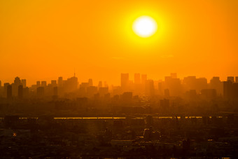 暗色调城市上空的太阳摄影图