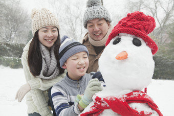 冬天堆雪人的一家三口