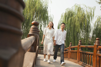 夫妻情侣男人女人河边桥上散步约会摄影图片