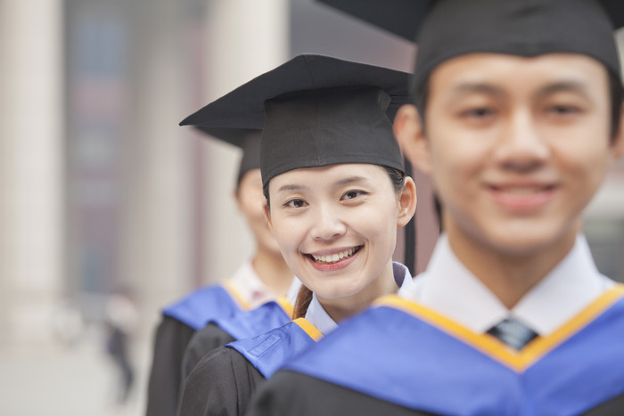 毕业男女开心的学位帽成人大学生大学微笑