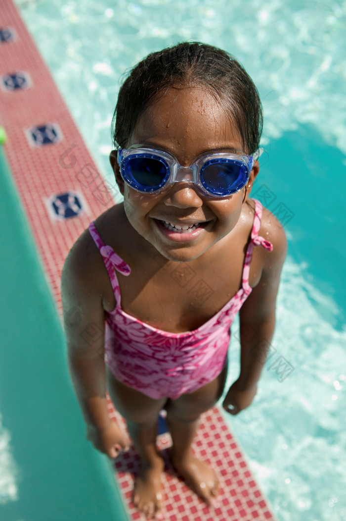 女孩戴着护目镜站在泳池旁