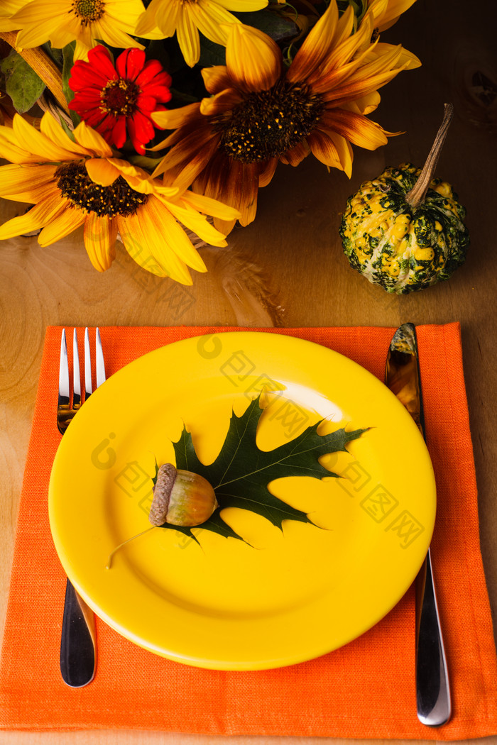 盘子里的枫叶和橡子摄影图