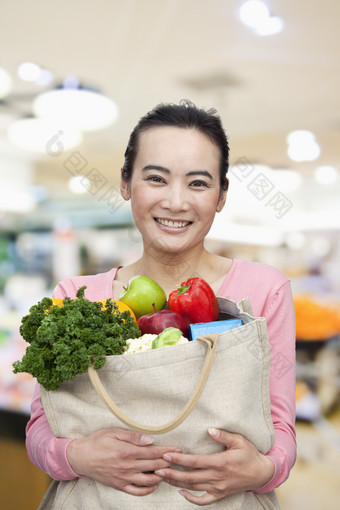 抱着一袋子蔬菜的女人