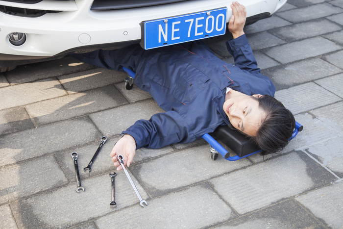 男人工作躺地上修理汽车维修人技能摄影图片