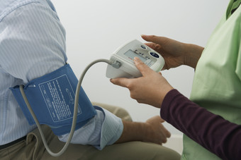 灰色调量血压的人摄影图