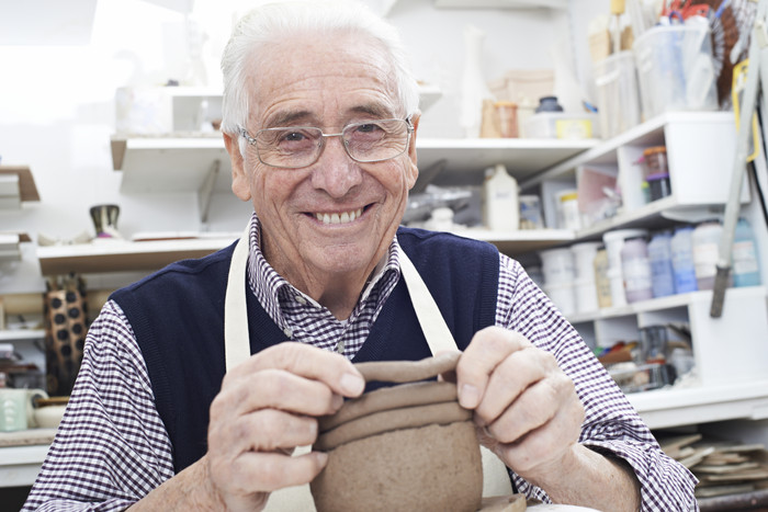 简约风学做陶器的老人摄影图