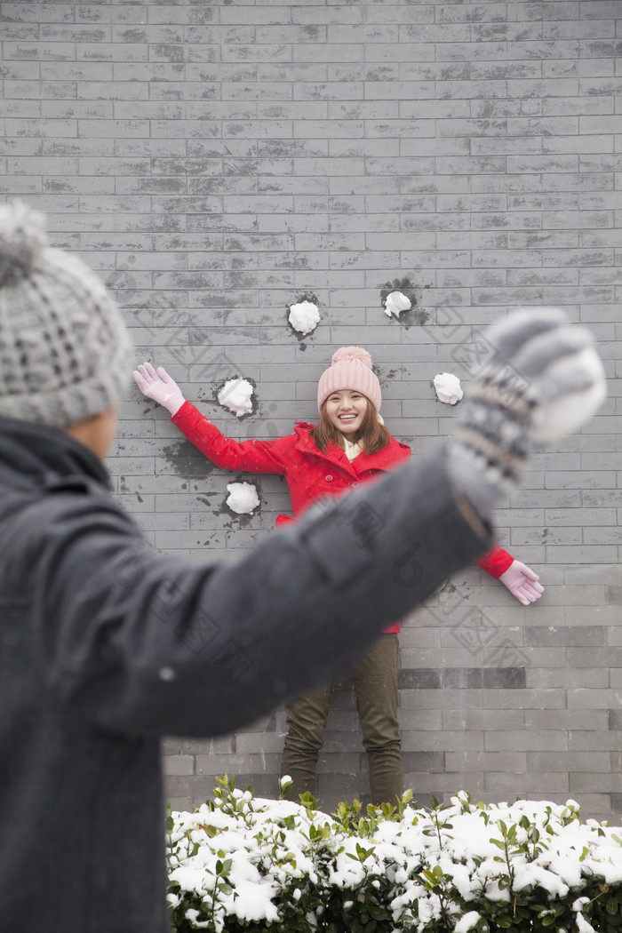 男孩女孩情侣冬天下雪寒冷的打雪仗玩耍摄影