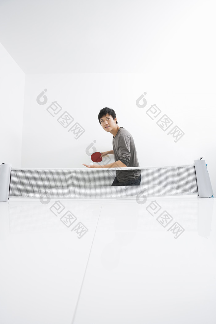 灰色调打乒乓球的男人摄影图