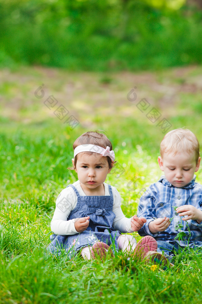 坐在草坪上的儿童摄影图