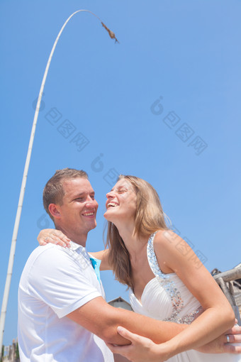 情侣男子女子拥抱微笑快乐蓝天度假旅行