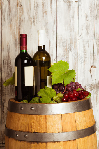 木屋中酒桶上的红酒和葡萄