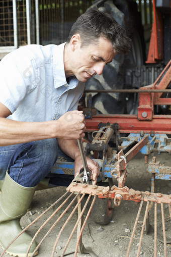 修理拖拉机设备的男人