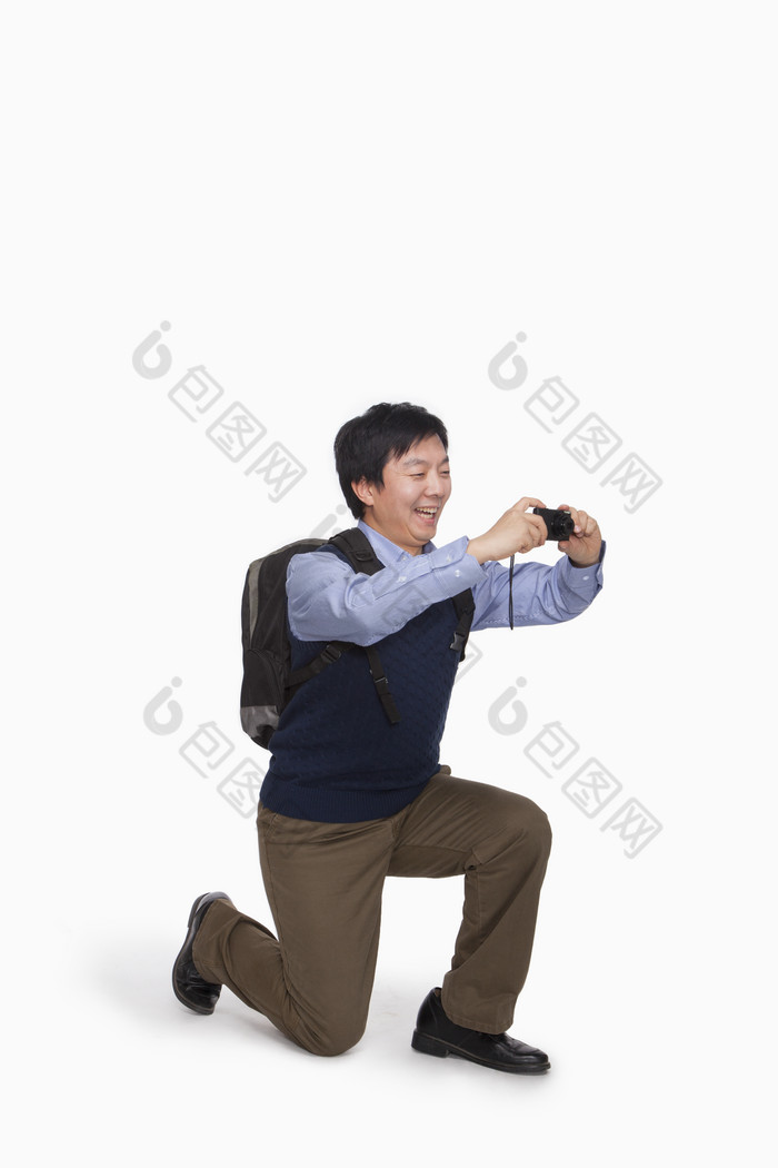单膝跪地拍照的男人
