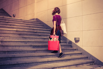 提购物袋的女人爬<strong>楼梯</strong>