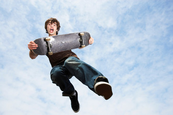 蓝色玩滑板的少年摄影图