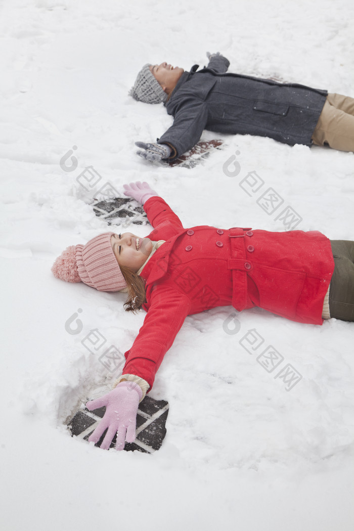 两个人男生女生躺雪地上冬天下雪休闲摄影