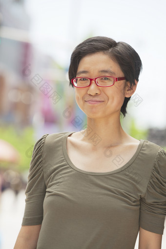 <strong>妇女</strong>戴眼镜的女人户外站着微笑摄影图