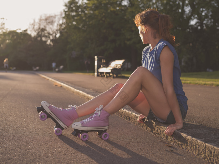 坐在路边的轮滑女孩图片