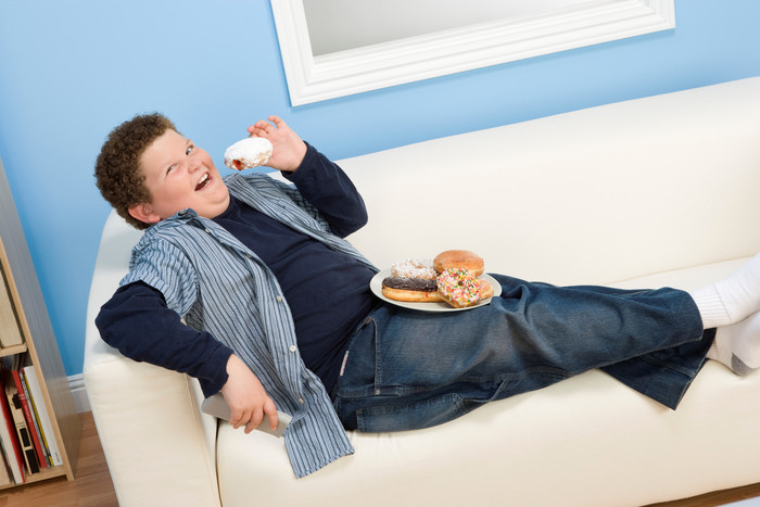 沙发吃甜食的肥胖小男孩