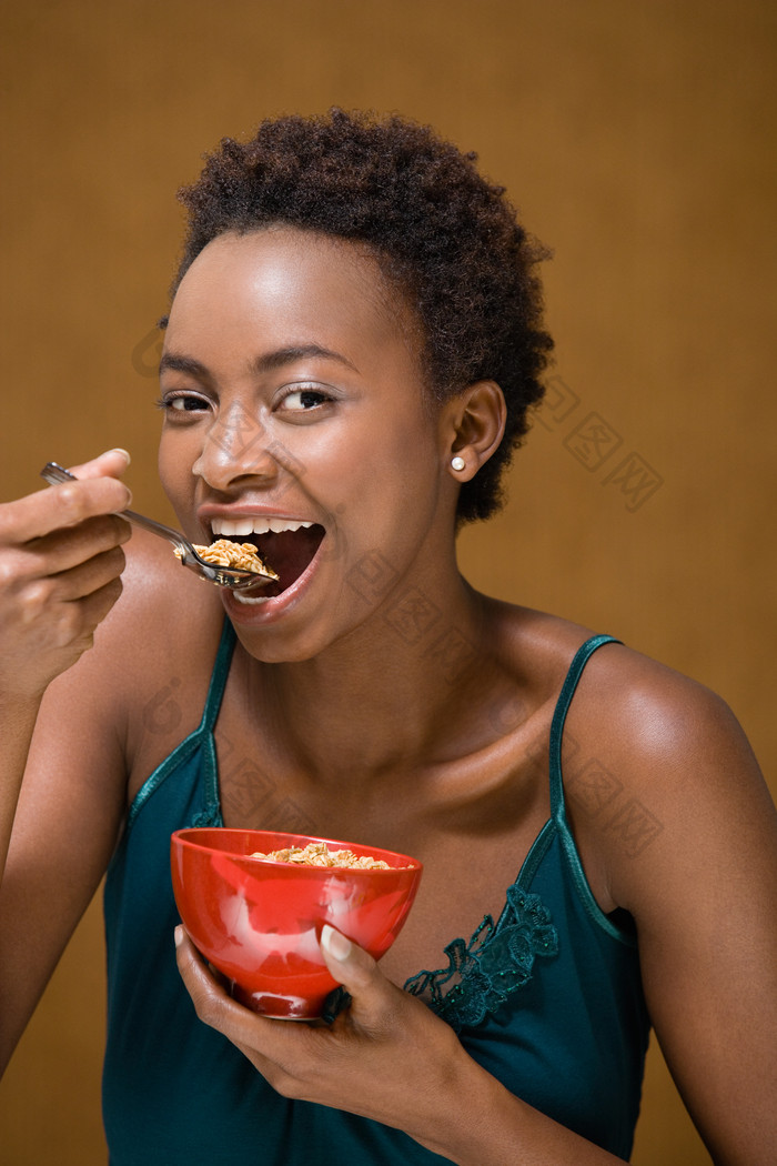 深色调吃东西的女人摄影图