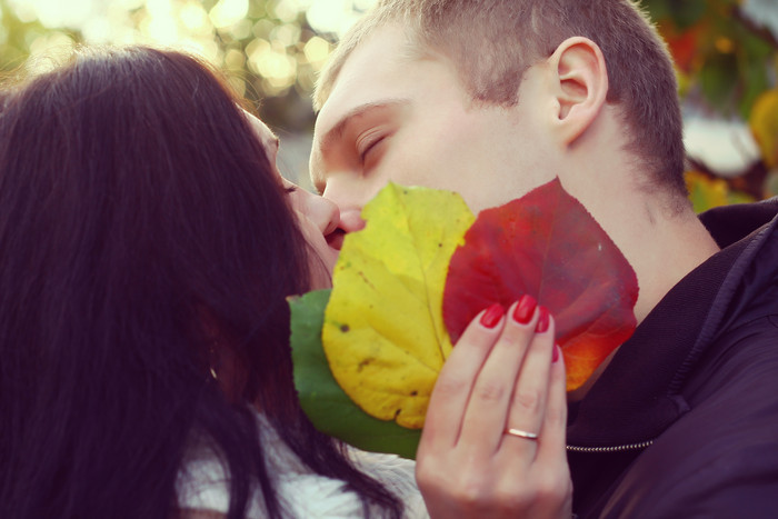 拿着树叶接吻的情侣