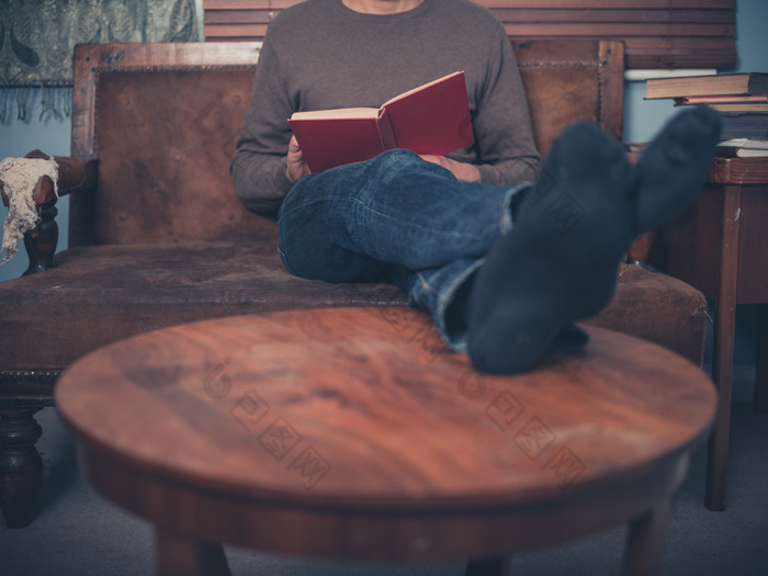 脚撘桌子上看书的男人