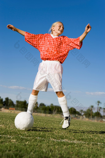 草坪踢足球的小女孩