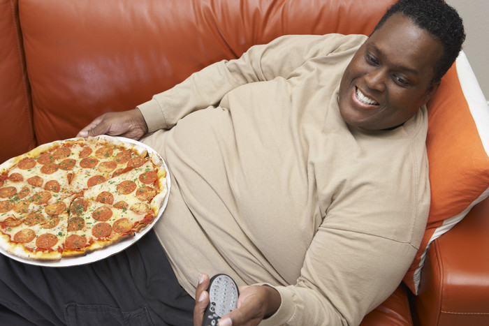 暗色调吃比萨的胖男人摄影图