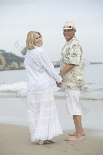 海滩牵手的夫妻摄影图
