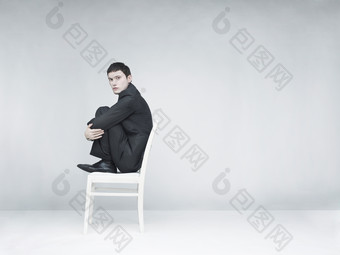 灰色调椅子上的男人摄影图
