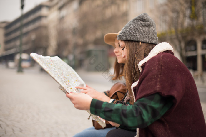 两个女孩坐在街头看地图图片