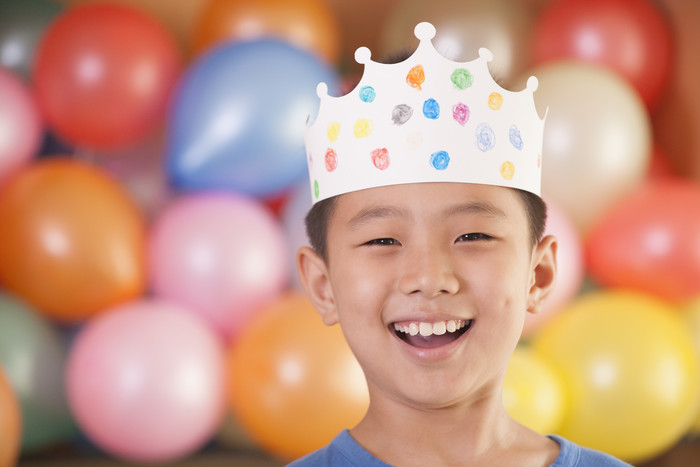 小男孩生日派对生日帽气球开心的微笑摄影图