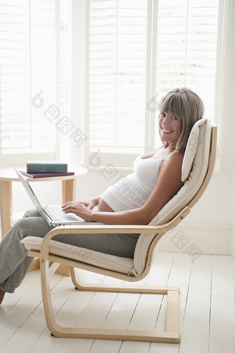 暗色调椅子上的<strong>孕妇</strong>摄影图