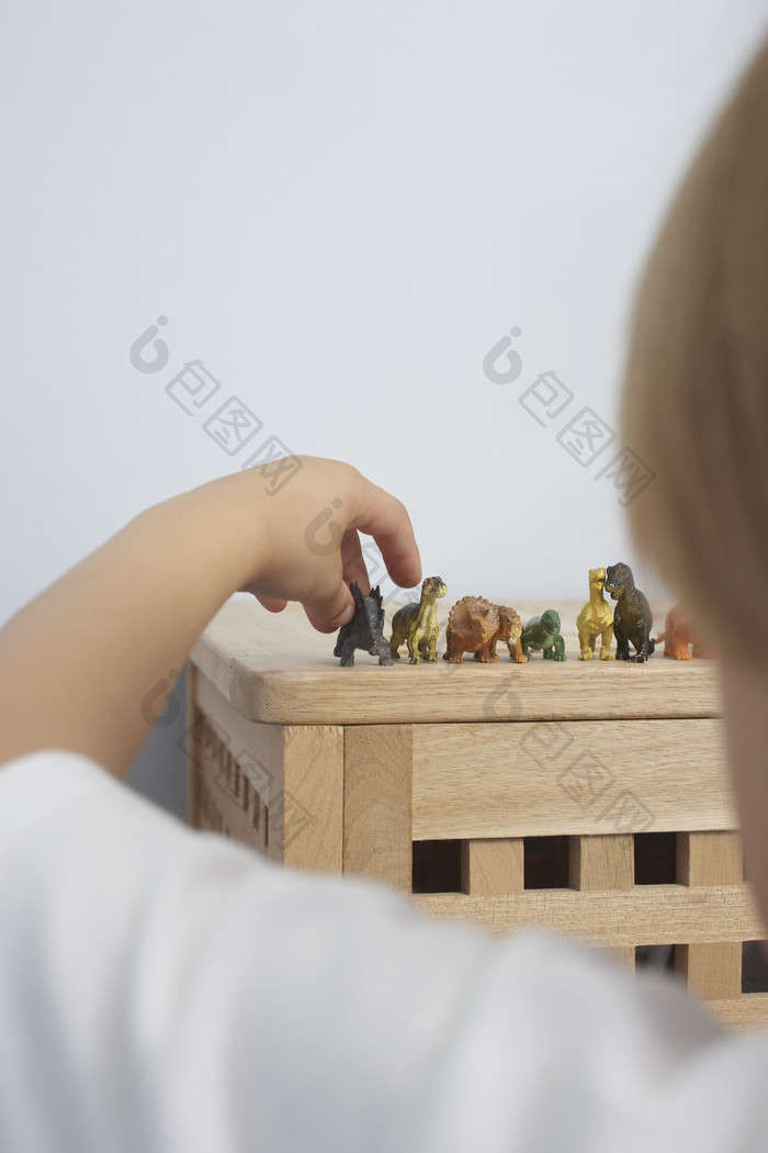 金发儿童玩耍恐龙玩具