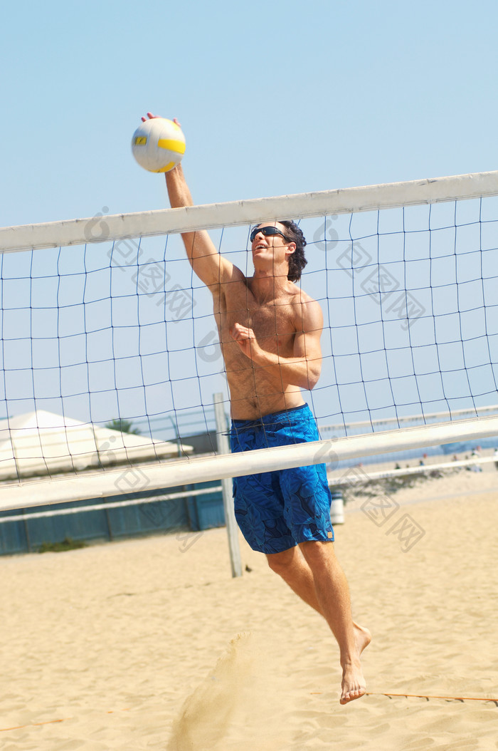 青年男士沙滩拍球