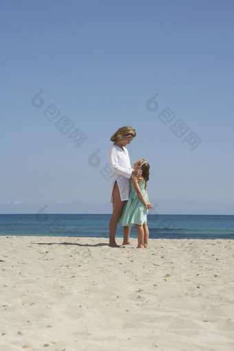 蓝色调沙滩上的母女摄影图