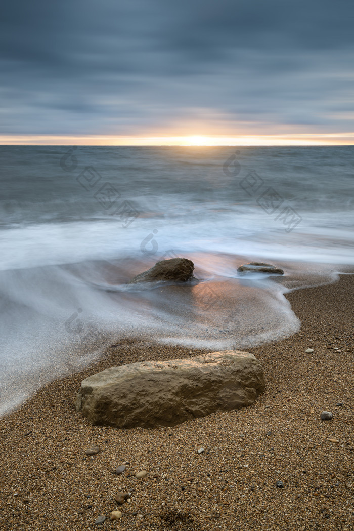 涨潮的海滩石头摄影图